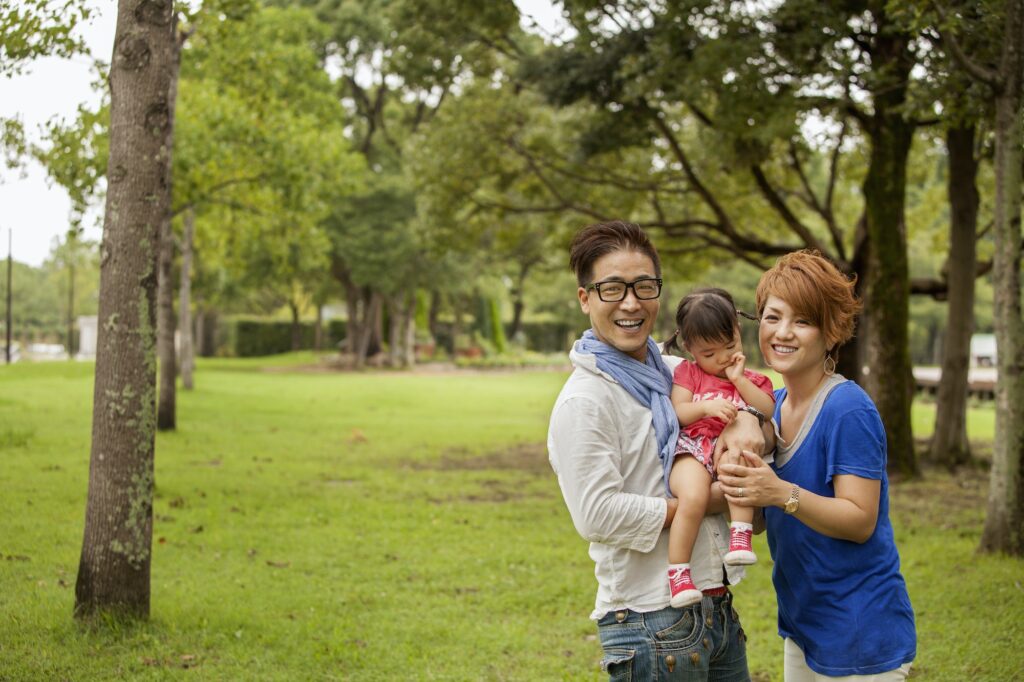 Family in a park. Two parents and a toddler.