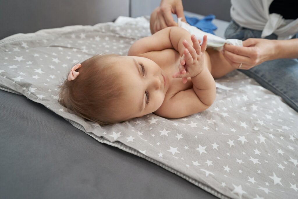 Person is putting on diaper on baby
